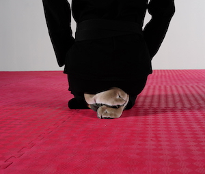 feet crossed as person kneels facing away from the camera